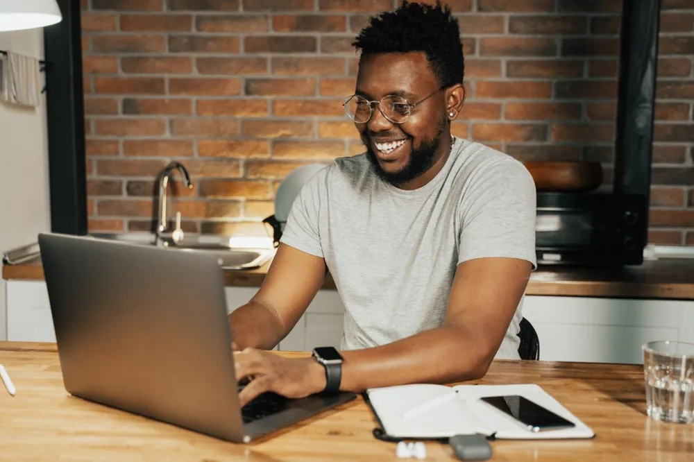 Smiling man working comfortably on a laptop